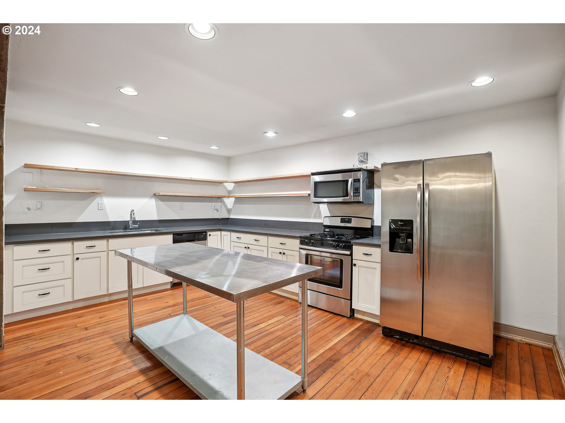 3903 North Michigan Avenue Portland, OR 97227 - Photo 18 of 47 a kitchen with stainless steel appliances kitchen island granite countertop a refrigerator a stove and a wooden floors