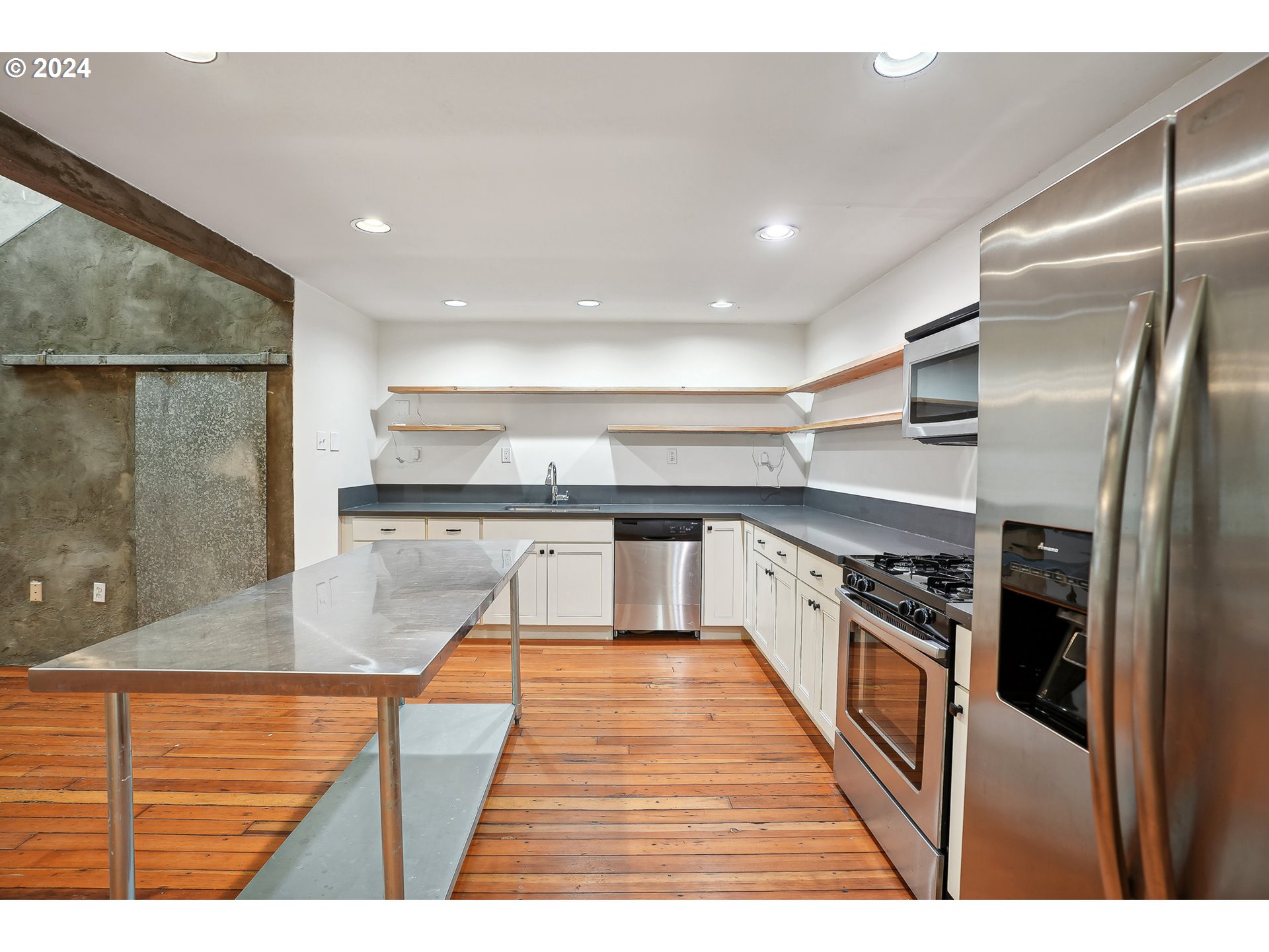 3903 North Michigan Avenue Portland, OR 97227 - Photo 20 of 47 a large kitchen with stainless steel appliances kitchen island a large counter top and a wooden floors