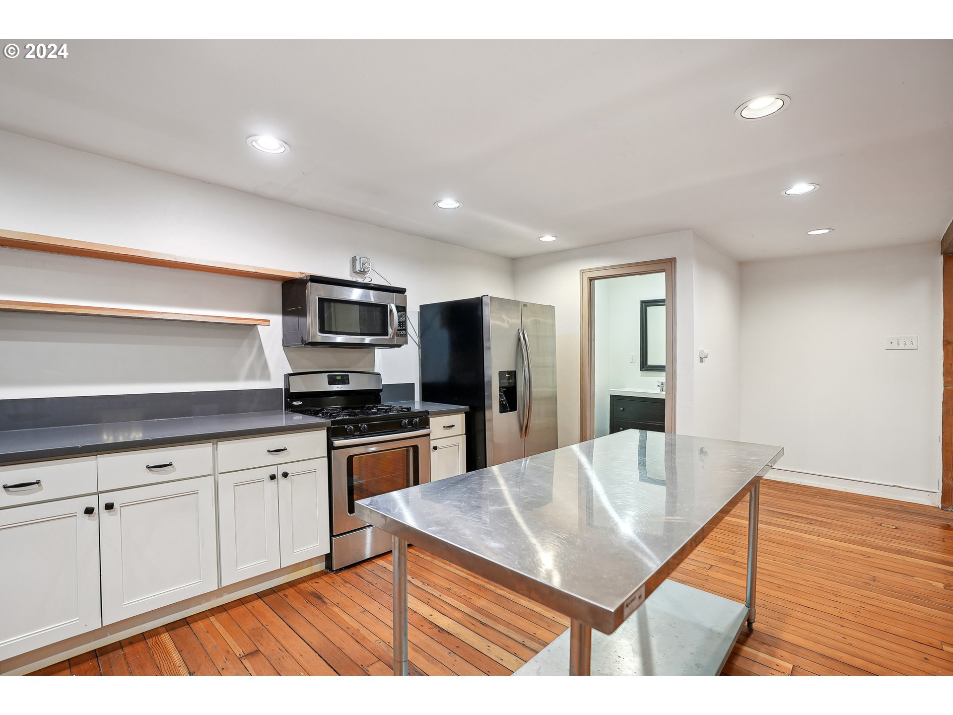 3903 North Michigan Avenue Portland, OR 97227 - Photo 24 of 47 a kitchen with stainless steel appliances kitchen island granite countertop a refrigerator a stove top oven and white cabinets