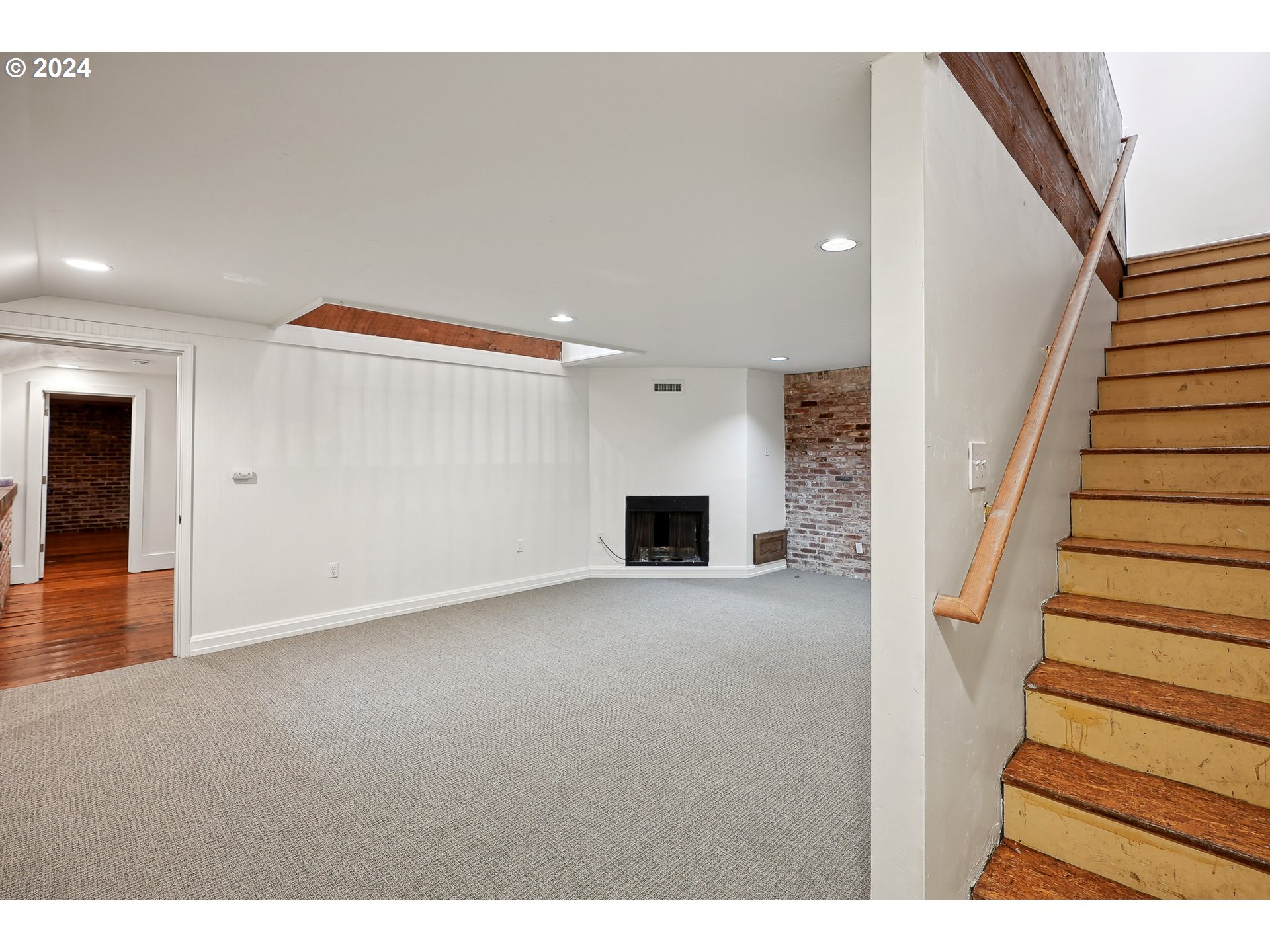 3903 North Michigan Avenue Portland, OR 97227 - Photo 10 of 47 a view of an empty room with wooden floor and a kitchen