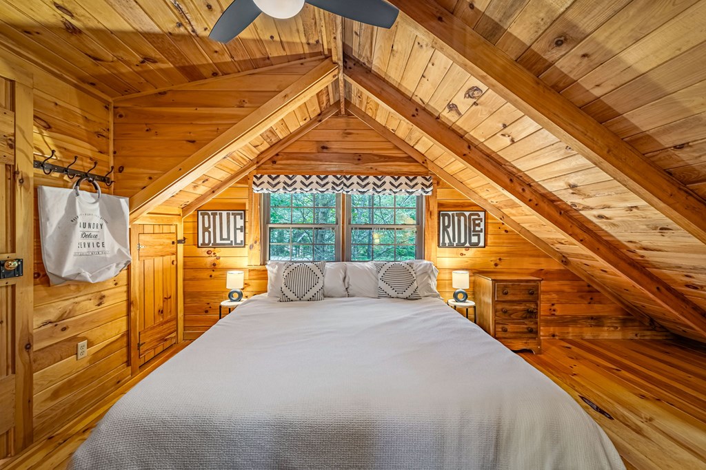 380 Branch Creek Road Blue Ridge, GA 30513 - Photo 18 of 41 a spacious bedroom with a bed and wooden floor