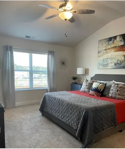 a bedroom with a large bed and a chandelier