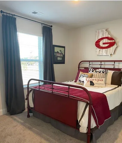 a bed sitting in a bedroom next to a window