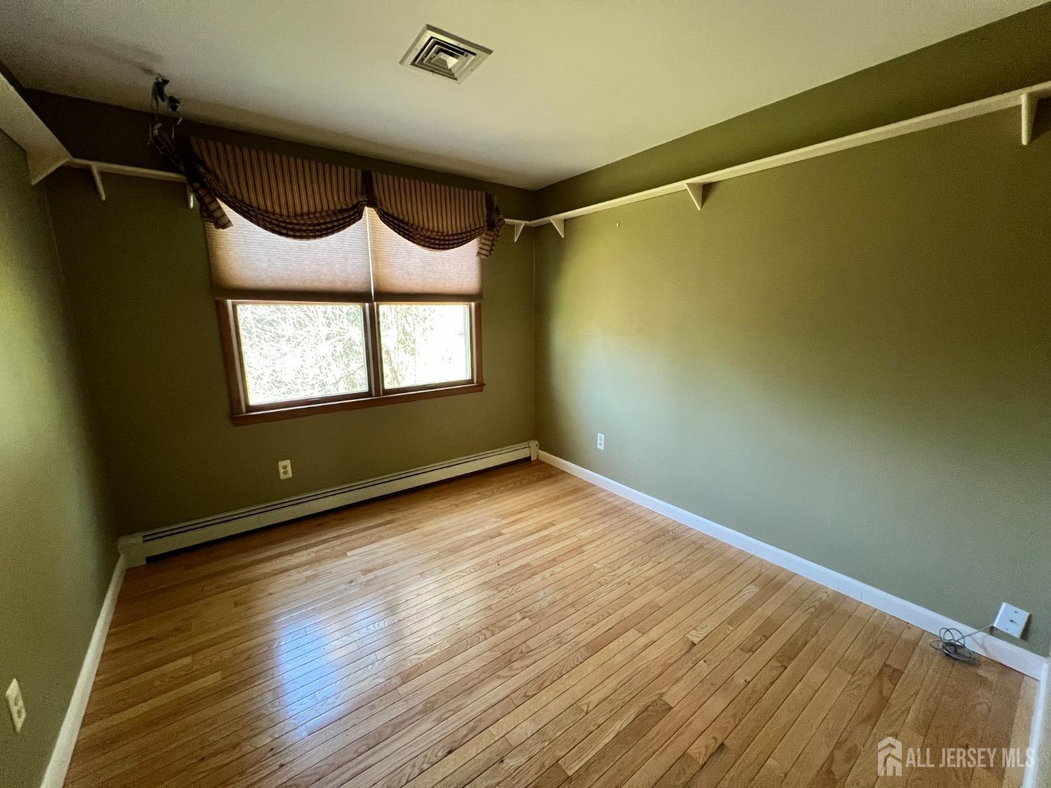 283 Rudetown Road Hamburg, NJ 07419 - Photo 13 of 38 a view of an empty room with a window and wooden floor