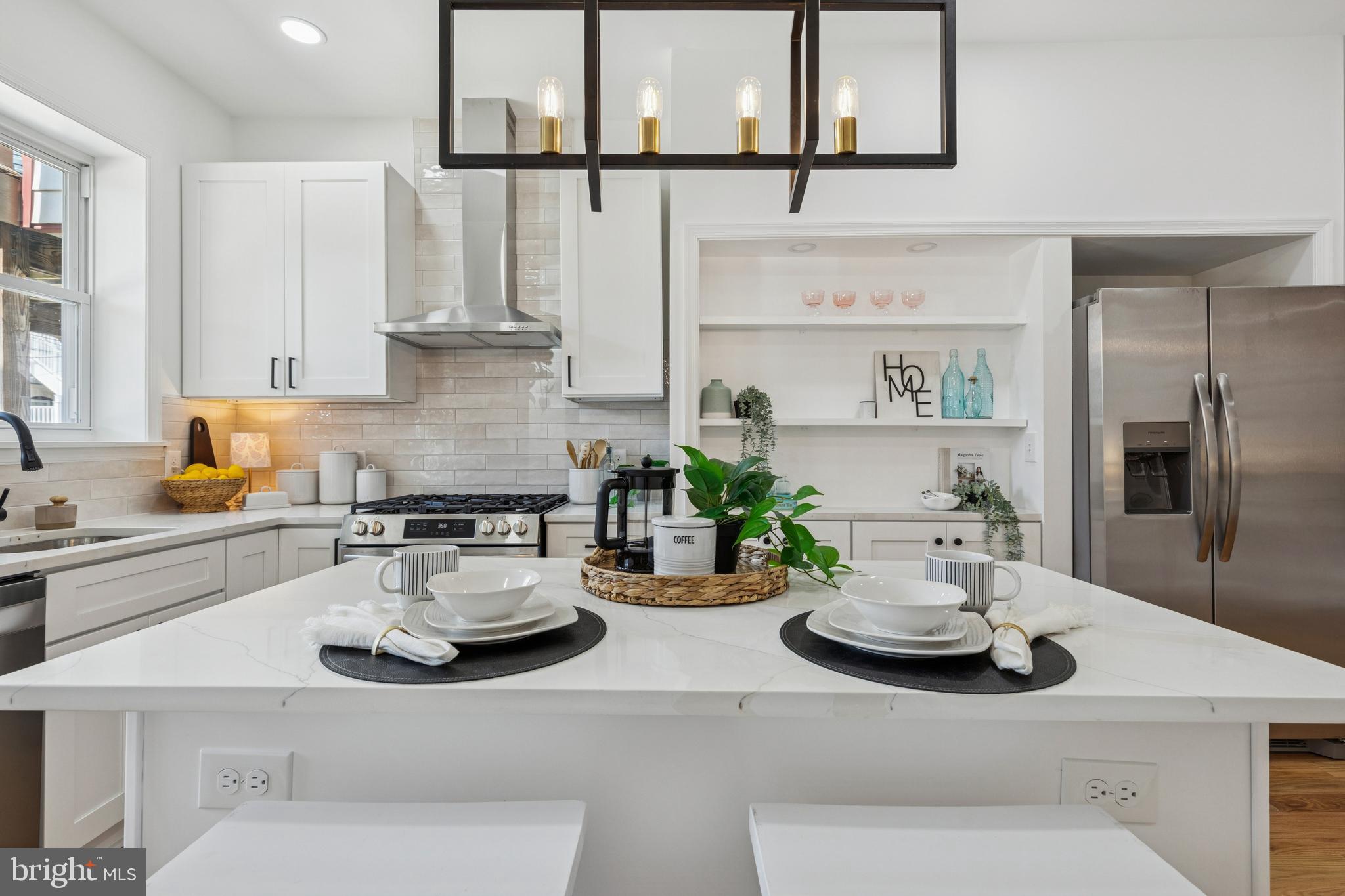 630 South Potomac Street Baltimore, MD 21224 - Photo 18 of 52 a kitchen with a sink stove and white cabinets with wooden floor