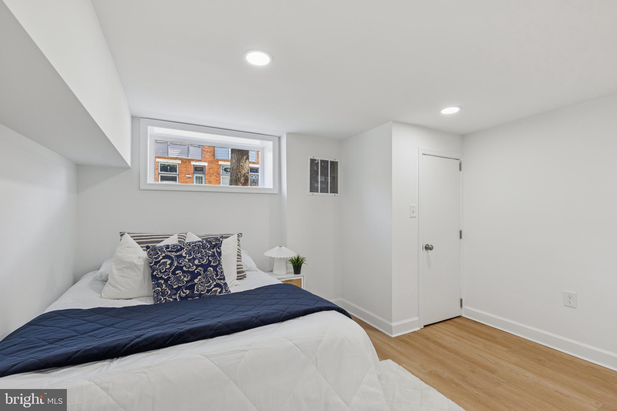 630 South Potomac Street Baltimore, MD 21224 - Photo 41 of 52 a bedroom with a bed and wooden floor