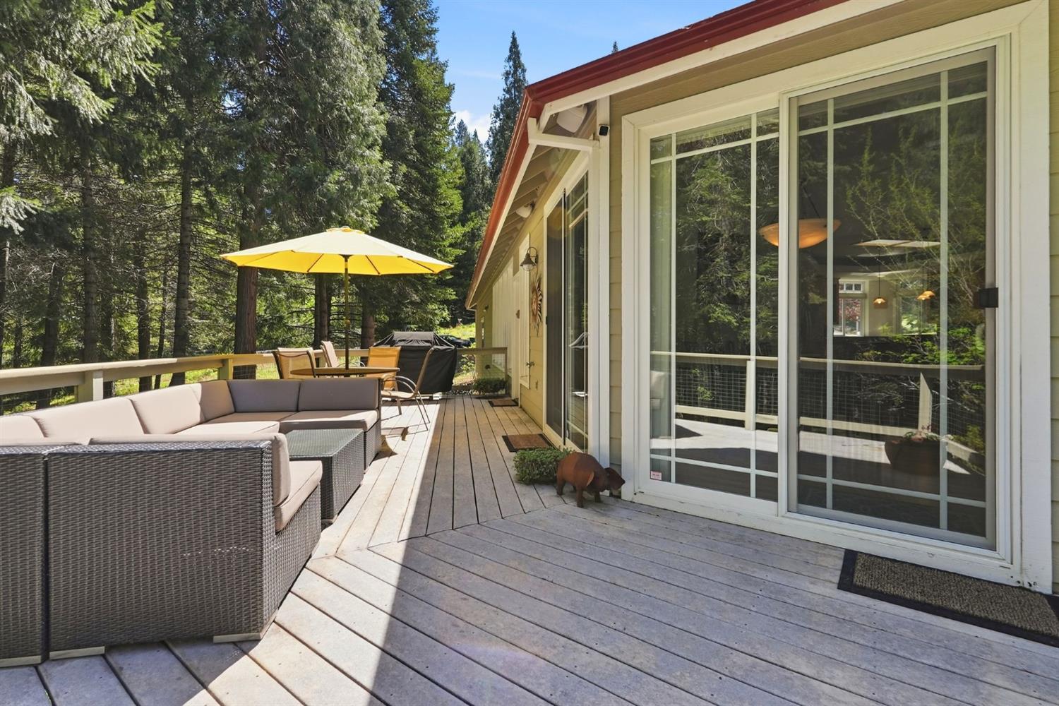 10711 Murchie Mine Road Nevada City, CA 95959 - Photo 49 of 71 a view of a roof deck with table and chairs under an umbrella with wooden floor and fence