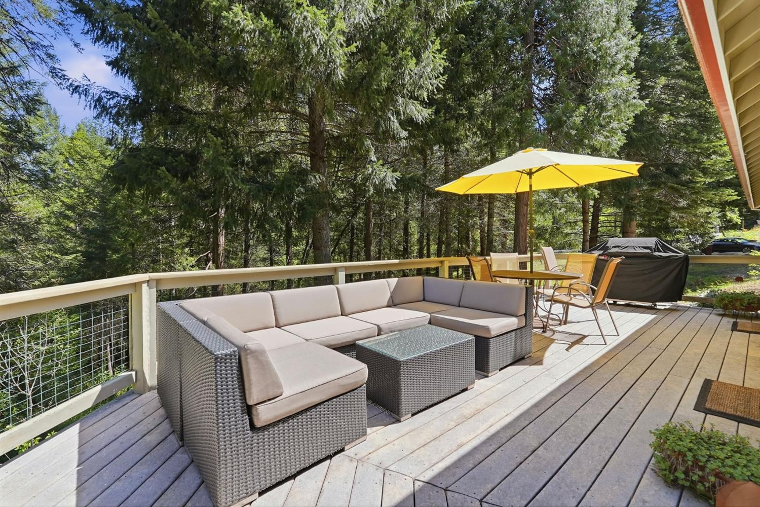 10711 Murchie Mine Road Nevada City, CA 95959 - Photo 50 of 71 a view of a roof deck with couches under an umbrella