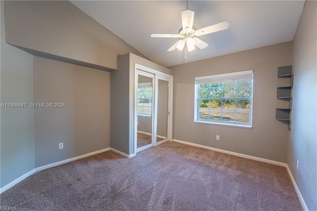 845 Quail Run LaBelle, FL 33935 - Photo 18 of 29 an empty room with chandelier fan and windows