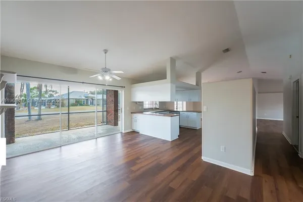 a view of large kitchen with granite countertop stainless steel appliances counter space and wooden floor
