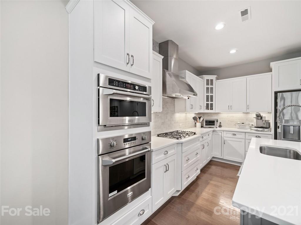2822 Walker Road Matthews, NC 28105 - Photo 12 of 47 a kitchen with white cabinets and stainless steel appliances