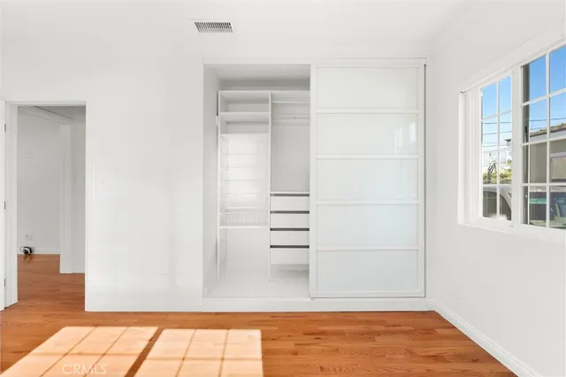 a view of walk in closet with empty racks