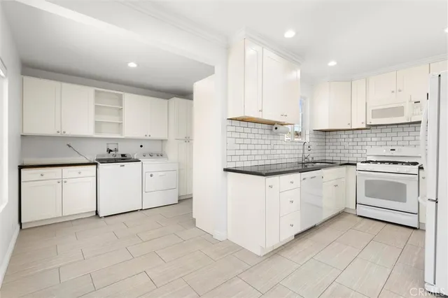 a kitchen with granite countertop white cabinets white stainless steel appliances with a sink and dishwasher