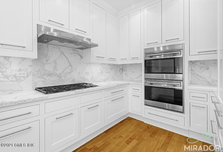 70 Forest Street, Unit 5E Stamford, CT 06901 - Photo 4 of 15 a kitchen with white cabinets and appliances
