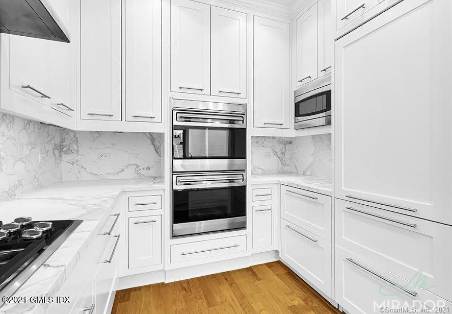 70 Forest Street, Unit 5E Stamford, CT 06901 - Photo 5 of 15 a kitchen with granite countertop white cabinets and appliances