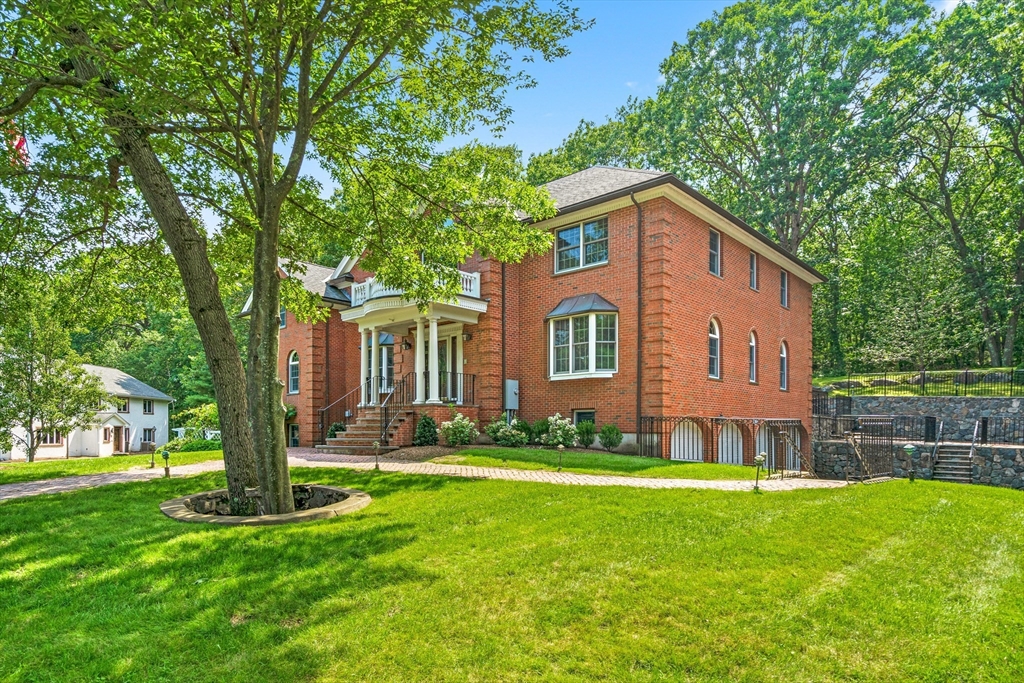 a front view of a house with a yard and trees