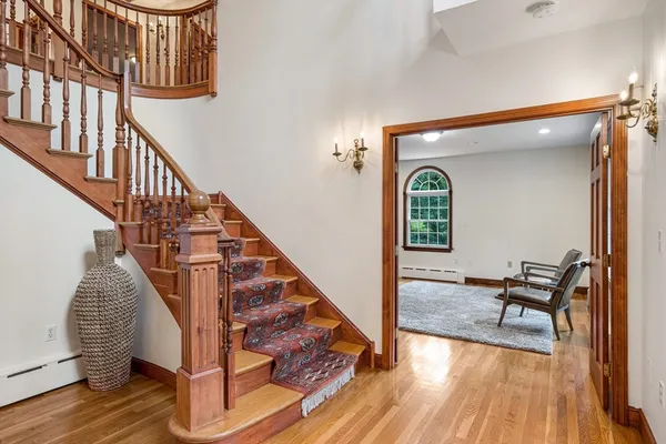 a view of a hallway with wooden floor and stairs