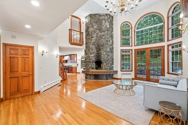 a living room with fireplace furniture and floor to ceiling windows