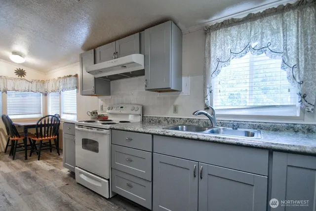 a kitchen with granite countertop white cabinets and white appliances
