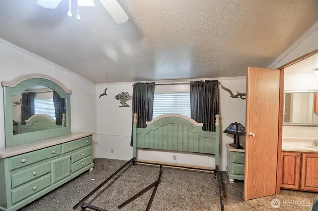 a bedroom with a bed and a mirror on the dresser