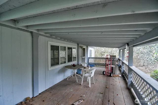a view of a porch with furniture and wooden floor