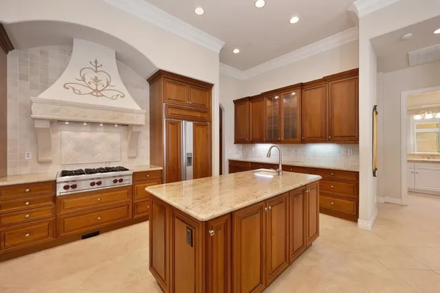 a large kitchen with stainless steel appliances kitchen island granite countertop a table and chairs in it