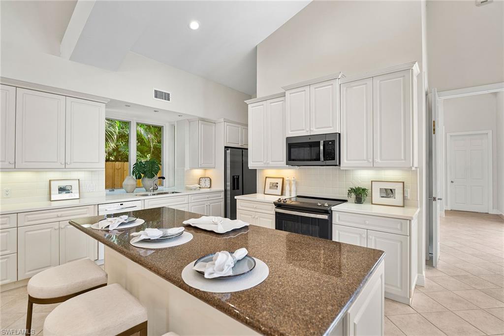 416 3rd Avenue North Naples, FL 34102 - Photo 18 of 50 a kitchen with a table chairs stove and microwave