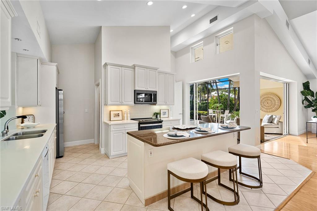 416 3rd Avenue North Naples, FL 34102 - Photo 19 of 50 a kitchen with stainless steel appliances granite countertop a stove refrigerator and cabinets