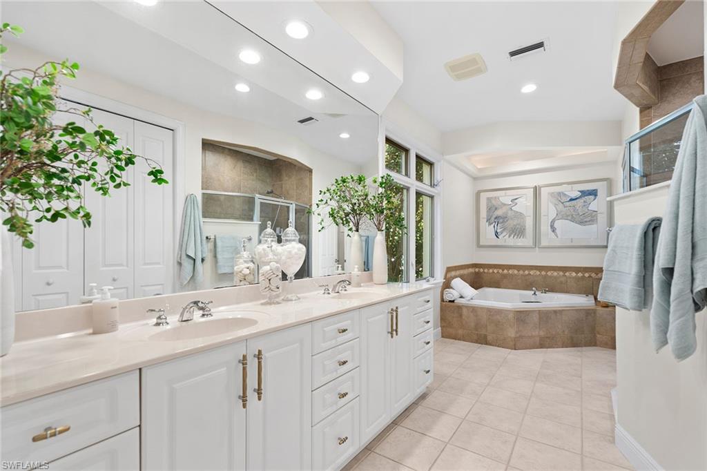 416 3rd Avenue North Naples, FL 34102 - Photo 27 of 50 a spacious bathroom with a granite countertop tub a double vanity sink and a large mirror