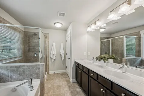a bathroom with a double vanity sink mirror and shower