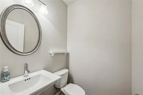 a bathroom with a sink a toilet and a mirror