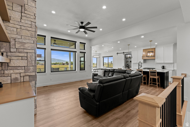 3111 South 1250 West Logan, UT 84321 - Photo 5 of 51 Expansive open-concept living space featuring wood-finish flooring and a stone accent wall