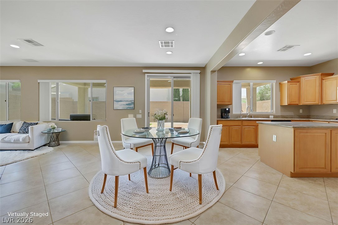 2501 Bechamel Place Henderson, NV 89044 - Photo 50 of 50 An open floorplan seamlessly connects the dining area, living space, and a well-appointed kitchen.