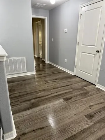 a view of empty room with wooden floor