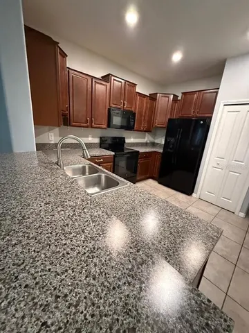 a kitchen with stainless steel appliances kitchen island granite countertop a sink and cabinets