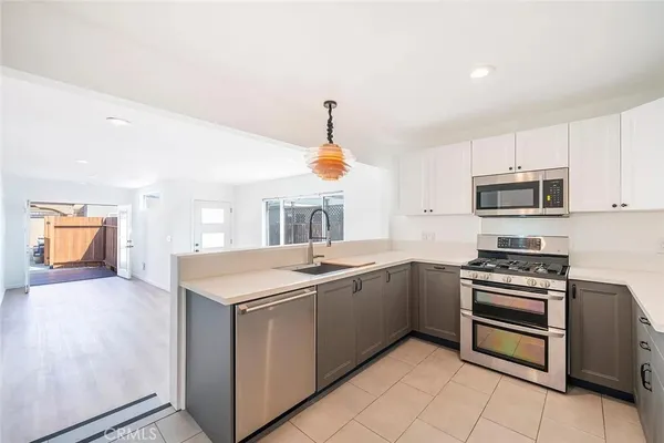 a kitchen with stainless steel appliances granite countertop a sink and dishwasher a stove top oven with wooden floor