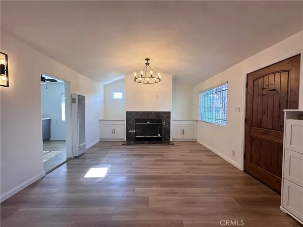 a view of empty room with wooden floor and window