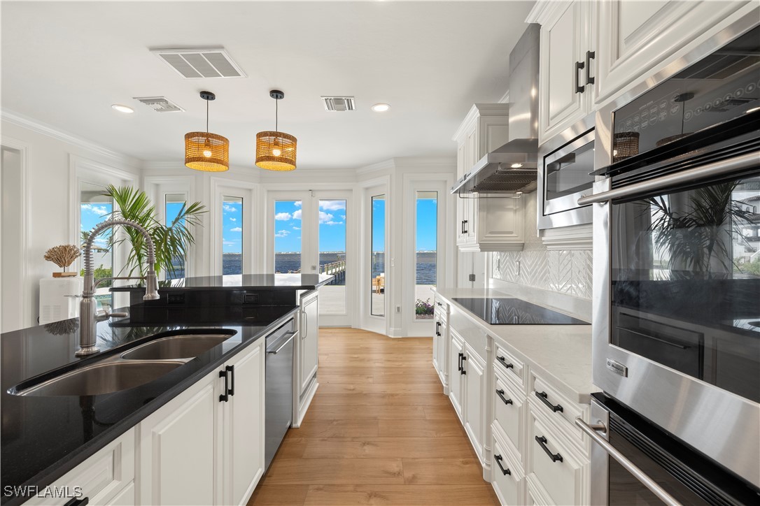8451 Casa Del Rio Lane Fort Myers, FL 33919 - Photo 11 of 50 a large white kitchen with stainless steel appliances granite countertop a lot of counter space and a sink