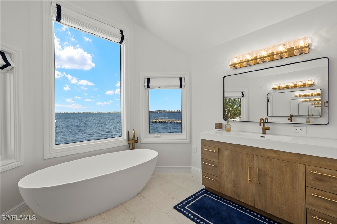 8451 Casa Del Rio Lane Fort Myers, FL 33919 - Photo 27 of 50 a bathroom with a bathtub sink and mirror