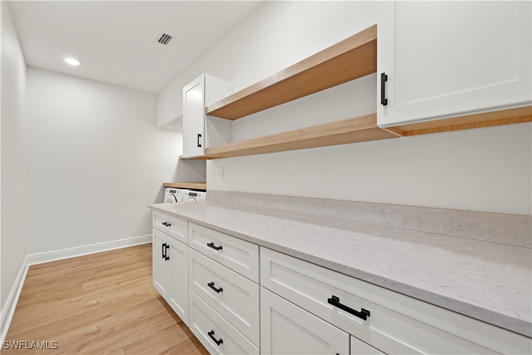 8451 Casa Del Rio Lane Fort Myers, FL 33919 - Photo 43 of 50 a kitchen with a white cabinets and wooden floor