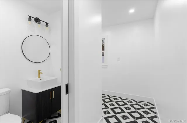 a bathroom with a sink mirror vanity and a toilet