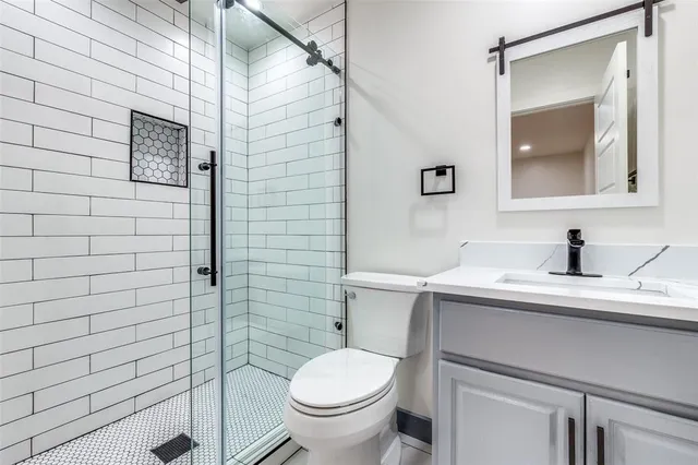 a bathroom with a granite countertop toilet sink and mirror