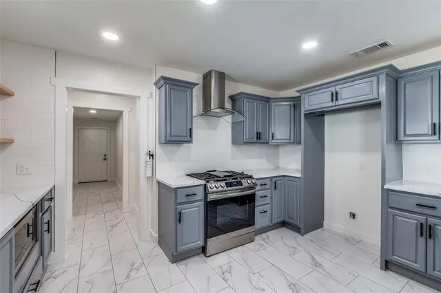 a kitchen with stainless steel appliances granite countertop a stove a sink and a refrigerator
