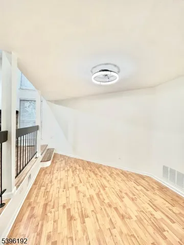 a view of a room with wooden floor and white walls