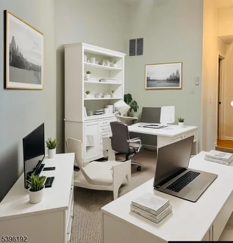 a work room with furniture a flat screen tv and a view of kitchen