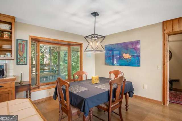 a dining room with furniture a chandelier and wooden floor