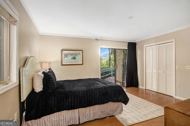 a bedroom with a bed painting on wall and a window