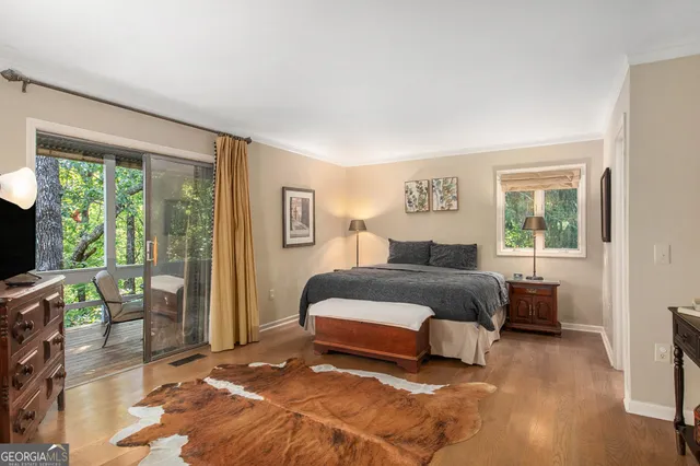 a spacious bedroom with a bed and a flat tv screen next to a window
