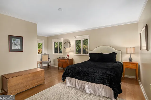 a large bed sitting in a bedroom next to a window with a table and chair