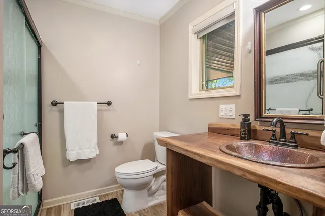 a bathroom with a granite countertop toilet sink and mirror